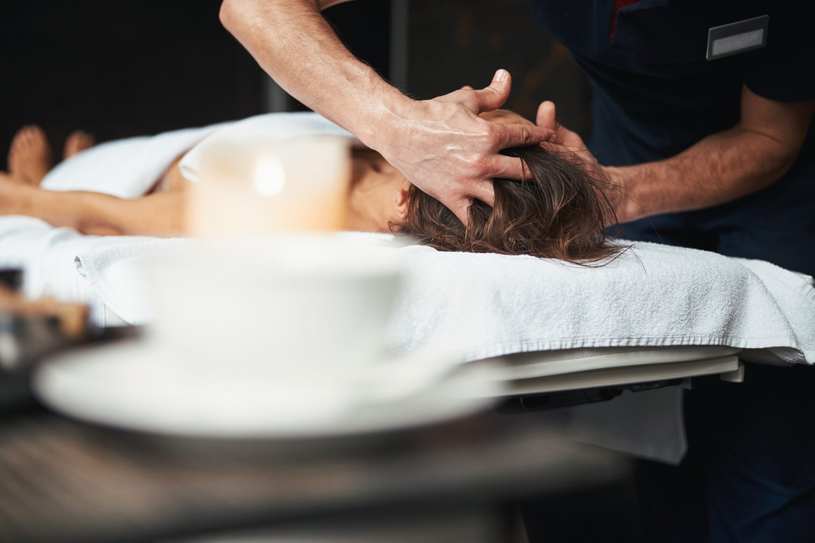 Cropped head portrait of strong male hands doing professional massage on patient head in health medical center